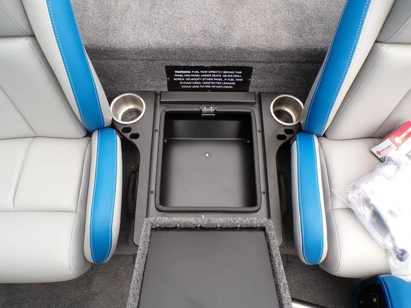 Slide: The Image of 2025 Phoenix 921 ELITE boat interior with blue and gray seats, cup holders, and storage compartment. - 6