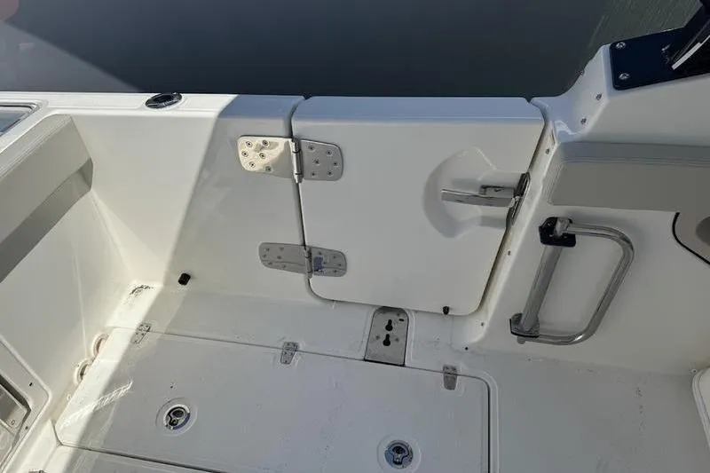 Slide: The Image of 2025 Boston Whaler 280 Vantage boat deck with secure door and stainless steel handle. - 10