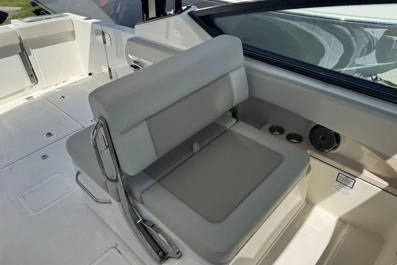 Slide: The Image of 2025 Boston Whaler 280 Vantage boat interior with cushioned seating and cup holders. - 11