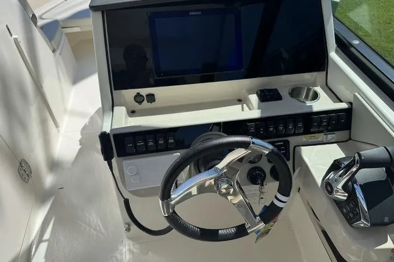 Slide: The Image of 2025 Boston Whaler 280 Vantage helm with steering wheel and control panel. - 3