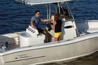 Slide: The Image of 2019 Pioneer 222 Sportfish boat with two people on deck, cruising on water. - 14