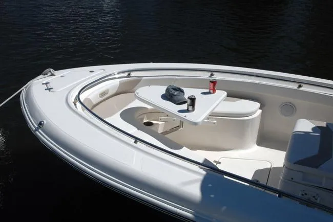 Slide: The Image of 2019 Pioneer 222 Sportfish boat with seating and table on calm water. - 16