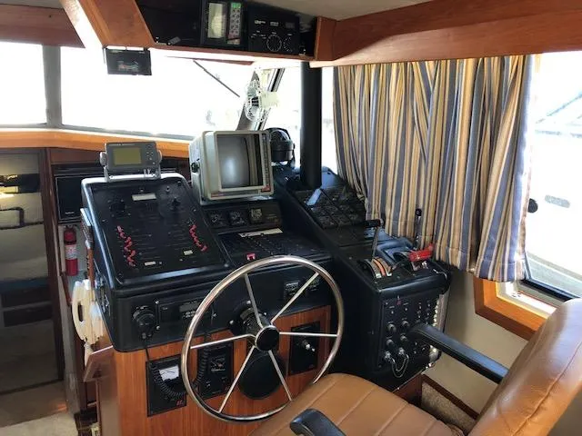 Slide: The Image of 1988 Bayliner 3818 Motoryacht helm with navigation equipment and striped curtains. - 11