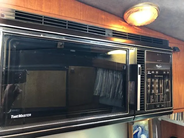 Slide: The Image of Microwave in 1988 Bayliner 3818 Motoryacht kitchen with wood paneling and overhead light. - 29