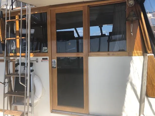 Slide: The Image of 1988 Bayliner 3818 Motoryacht with wooden door and ladder, exterior view. - 3