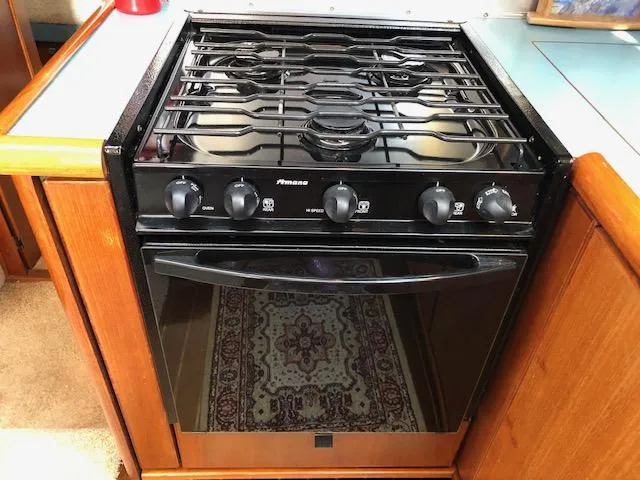 Slide: The Image of Black stove and oven in 1988 Bayliner 3818 Motoryacht kitchen, surrounded by wooden cabinetry. - 30