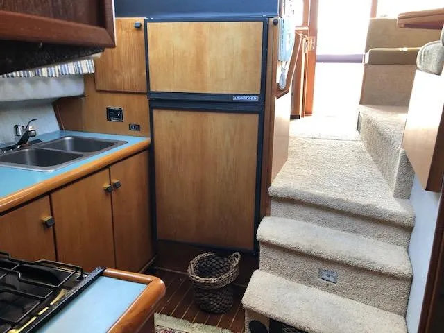 Slide: The Image of Interior of 1988 Bayliner 3818 Motoryacht with kitchen, stairs, and wooden cabinetry. - 33