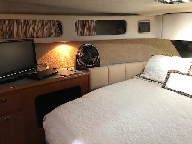 Slide: The Image of Cozy cabin interior of 1988 Bayliner 3818 Motoryacht with bed, fan, and TV. - 35