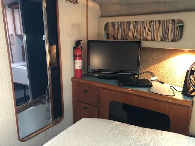 Slide: The Image of 1988 Bayliner 3818 Motoryacht interior with TV, fire extinguisher, and wooden cabinetry. - 36