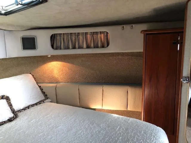 Slide: The Image of Interior cabin of 1988 Bayliner 3818 Motoryacht with bed, wood paneling, and soft lighting. - 37