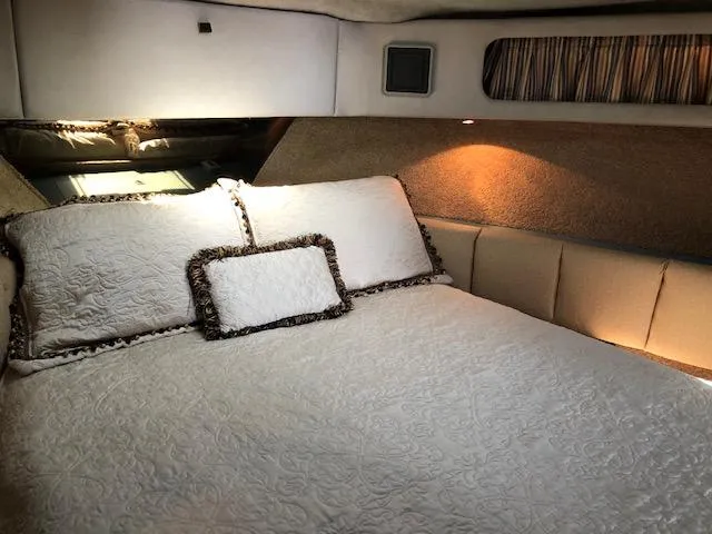 Slide: The Image of Cozy bedroom interior of 1988 Bayliner 3818 Motoryacht with elegant bedding and soft lighting. - 38