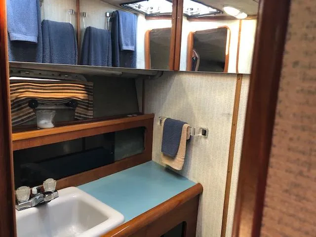 Slide: The Image of 1988 Bayliner 3818 Motoryacht bathroom with sink, mirror, and blue towels. - 39