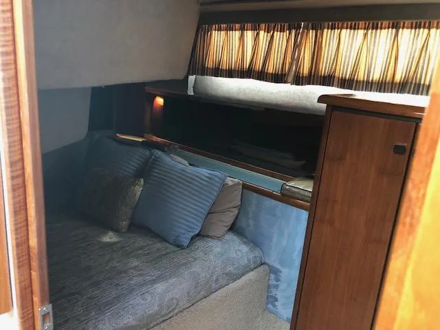 Slide: The Image of Cozy cabin interior of 1988 Bayliner 3818 Motoryacht with bed and wooden cabinetry. - 41