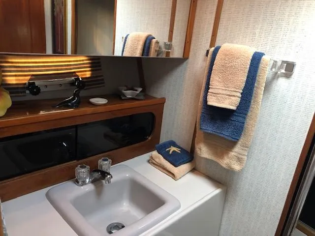 Slide: The Image of 1988 Bayliner 3818 Motoryacht bathroom with sink, mirror, and neatly arranged towels. - 44