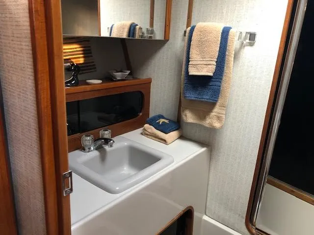 Slide: The Image of 1988 Bayliner 3818 Motoryacht bathroom with sink, mirror, and neatly arranged towels. - 45