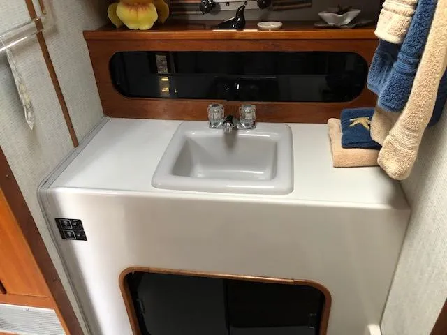 Slide: The Image of 1988 Bayliner 3818 Motoryacht bathroom sink with towels and wooden accents. - 46