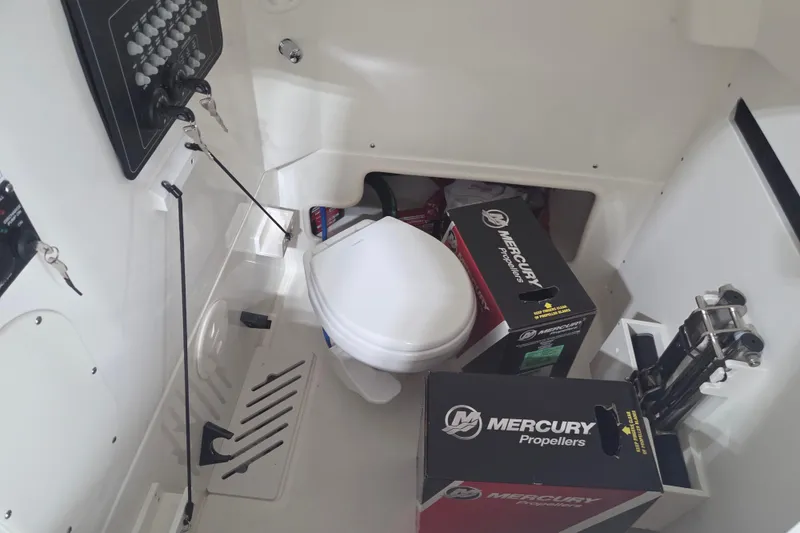 Slide: The Image of 2026 Boston Whaler 280 Outrage interior with Mercury propeller boxes and marine toilet. - 10