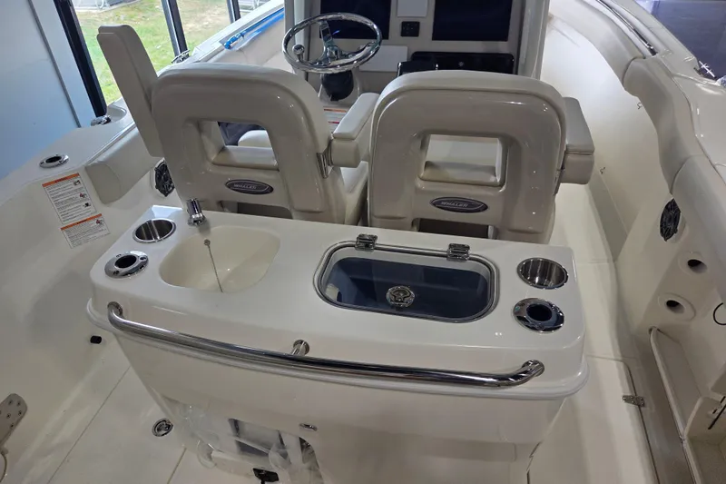 Slide: The Image of 2026 Boston Whaler 280 Outrage boat interior with helm seats and console features. - 7