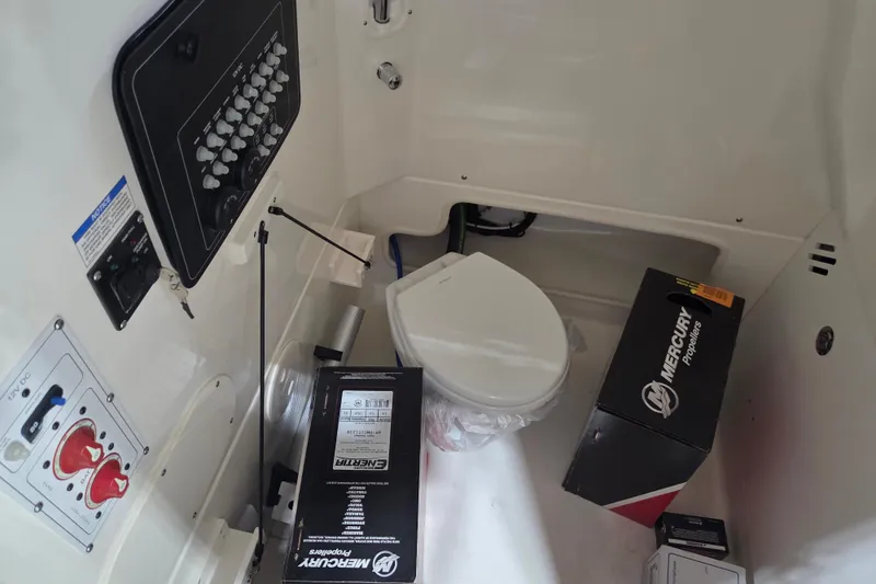 Slide: The Image of 2025 Boston Whaler 250 Outrage interior with control panel and marine toilet. - 13