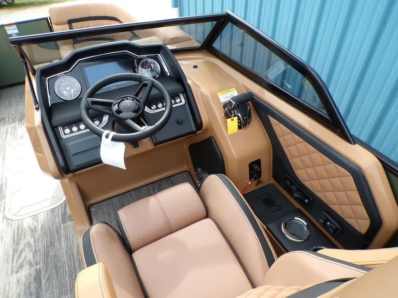 Slide: The Image of Interior of 2025 Godfrey AquaPatio 235 SBW boat, featuring modern dashboard and tan seating. - 7