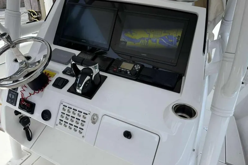 Slide: The Image of Console of a 2012 Intrepid 32 Open boat with steering wheel and navigation screens. - 6