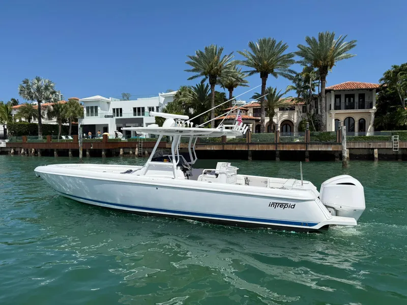 The Image of 2012 Intrepid 32 Open boat on water near luxury waterfront homes. - 1