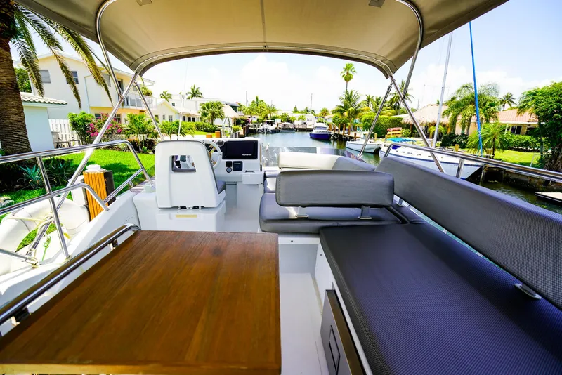 Slide: The Image of Flybridge view of 2017 Azimut 42 Fly yacht with seating and table, docked in a scenic canal. - 16