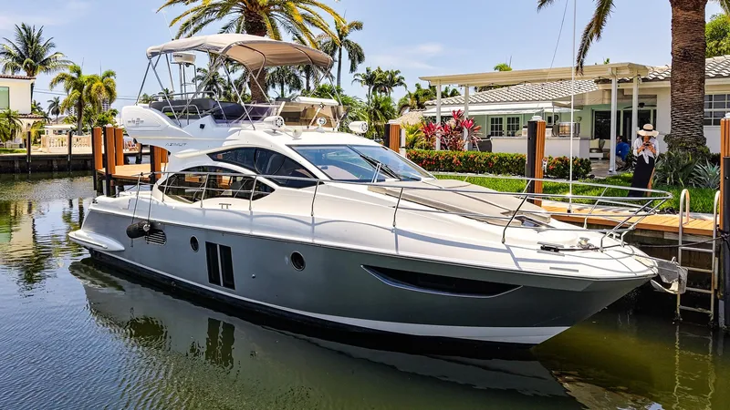 Slide: The Image of 2017 Azimut 42 Fly yacht docked in a sunny, tropical marina setting. - 2