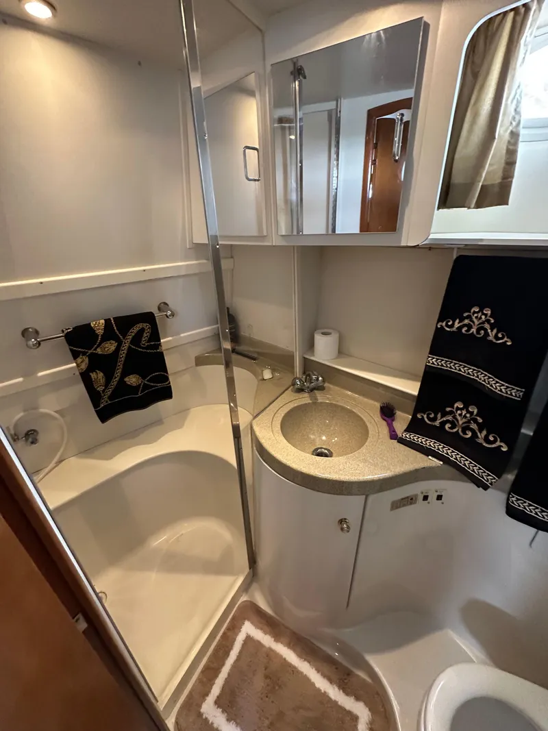 Slide: The Image of 2002 Carver AFT CABIN bathroom with shower, sink, and elegant black towels. - 11