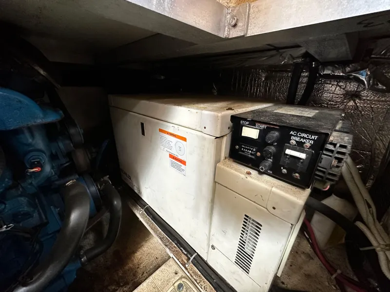 Slide: The Image of Engine room of 2002 Carver AFT CABIN with generator and AC circuit breaker. - 17