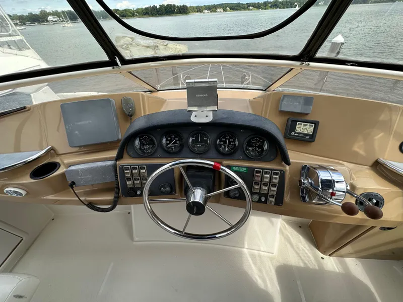 Slide: The Image of 2002 Carver AFT CABIN helm with steering wheel, gauges, and controls on a boat. - 18