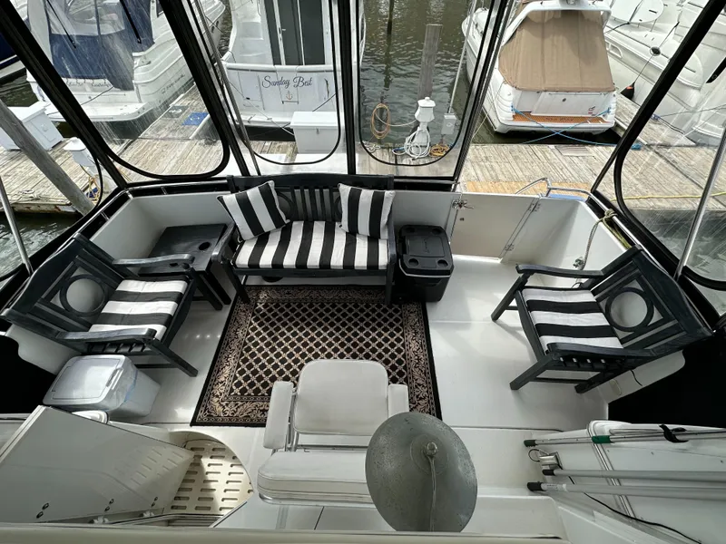 Slide: The Image of 2002 Carver AFT CABIN yacht interior with striped seating and marina view. - 20