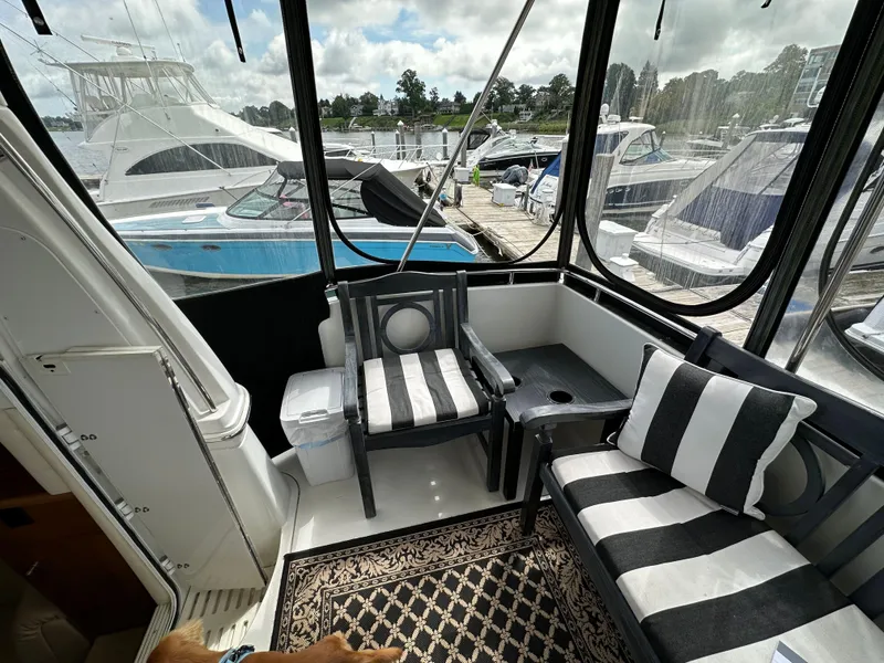 Slide: The Image of 2002 Carver AFT CABIN yacht interior with striped seating, docked at marina. - 22