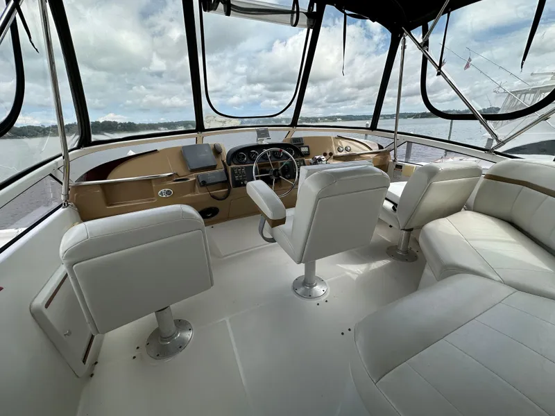 Slide: The Image of 2002 Carver AFT CABIN yacht interior with white seating and steering console. - 23