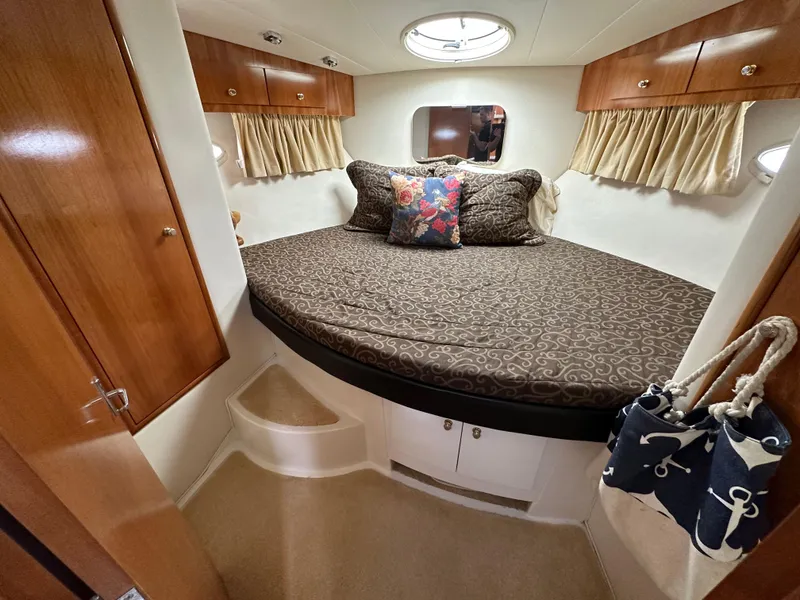 Slide: The Image of 2002 Carver AFT CABIN bedroom with cozy bed, wooden cabinets, and nautical decor. - 4