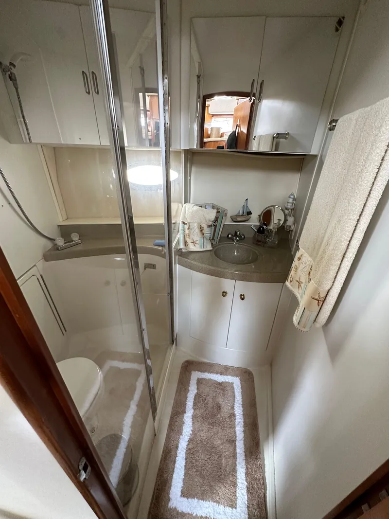 Slide: The Image of 2002 Carver AFT CABIN bathroom with shower, sink, and storage cabinets. - 5