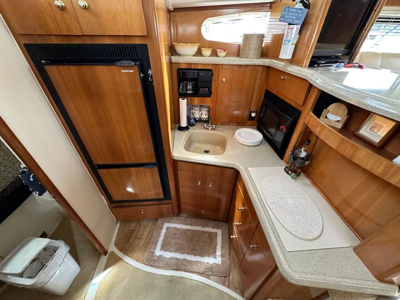 Slide: The Image of Interior of 2002 Carver AFT CABIN yacht with kitchenette and wooden cabinetry. - 6