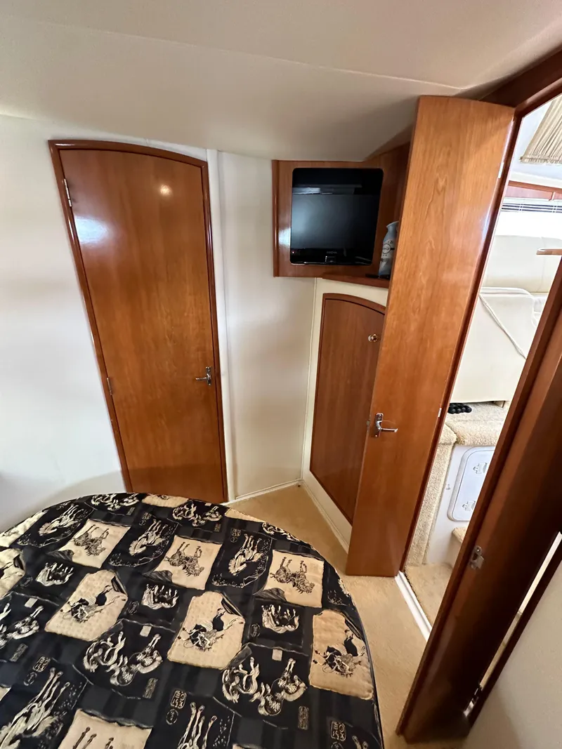 Slide: The Image of 2002 Carver AFT CABIN interior with wood cabinetry and patterned bedding. - 9