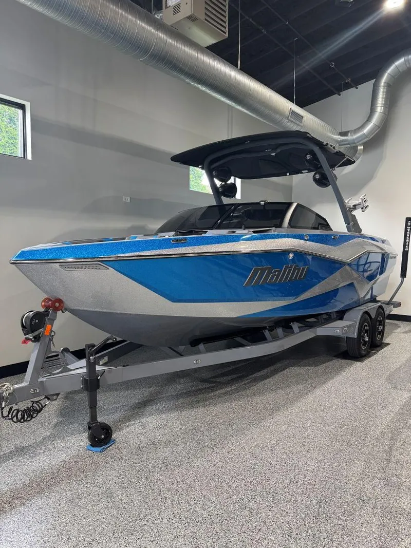 Slide: The Image of 2022 Malibu Wakesetter 25 LSV boat in showroom, blue and silver design. - 1