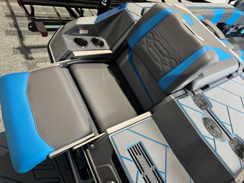 Slide: The Image of 2022 Malibu Wakesetter 25 LSV interior with blue and gray seating, cup holders, and sleek design. - 15