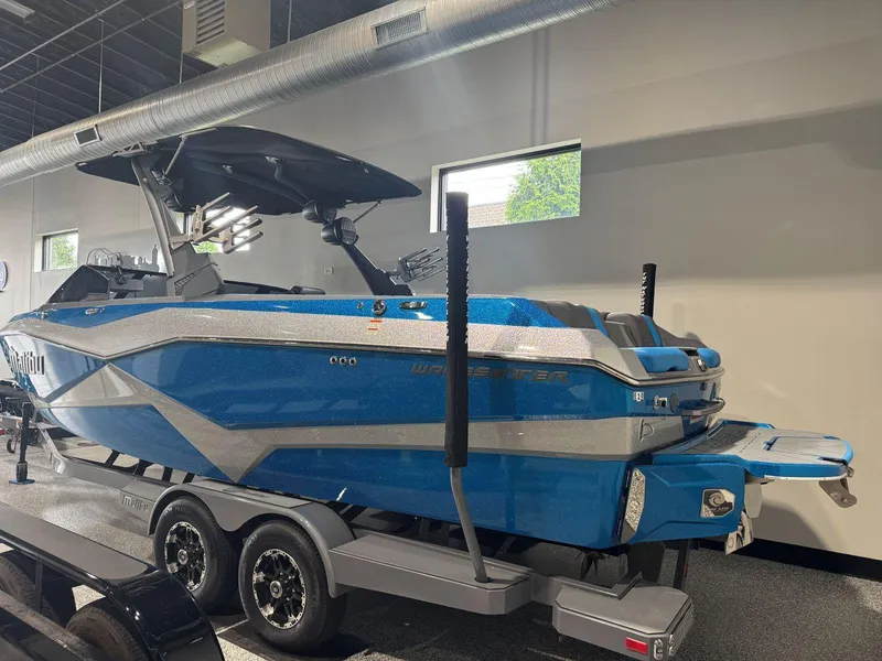 Slide: The Image of 2022 Malibu Wakesetter 25 LSV boat in showroom, blue and silver design. - 3