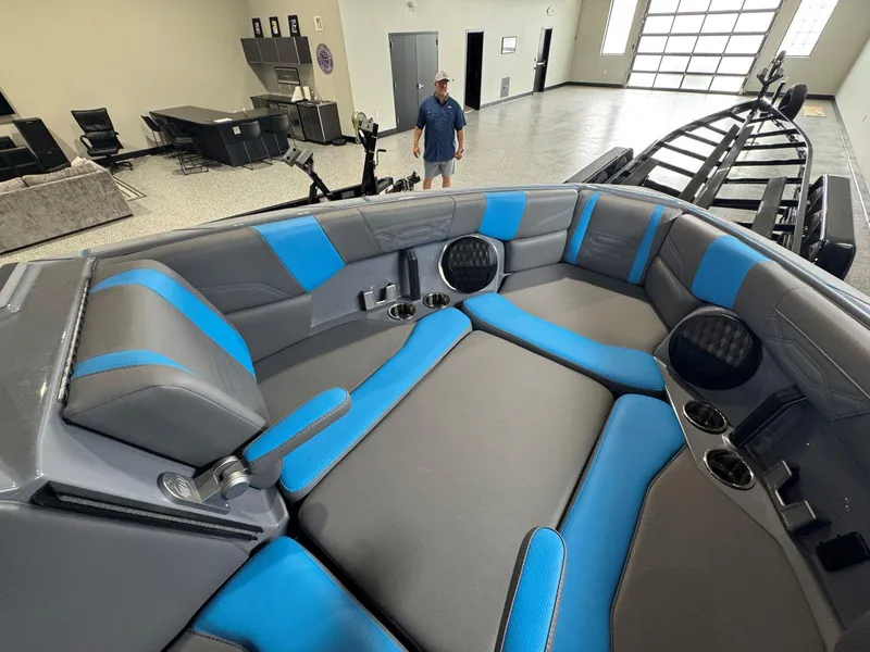 Slide: The Image of 2022 Malibu Wakesetter 25 LSV interior with blue and gray seating in showroom. - 40