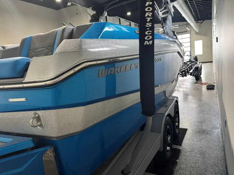 Slide: The Image of 2022 Malibu Wakesetter 25 LSV boat in showroom, blue and silver design. - 6