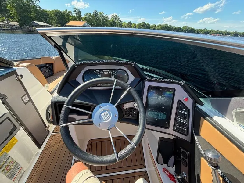 Slide: The Image of 2019 MasterCraft XStar boat cockpit with steering wheel and control panel on a sunny day. - 10