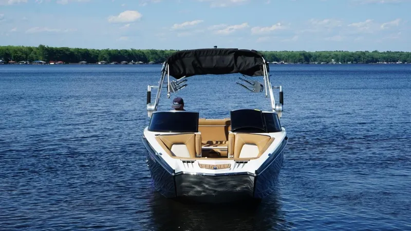 Slide: The Image of 2019 MasterCraft XStar boat on a calm lake under a clear blue sky. - 3