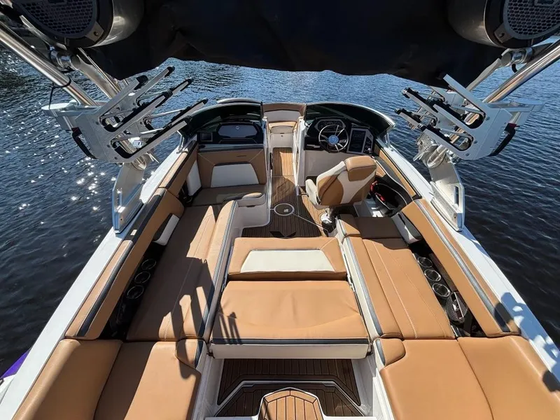 Slide: The Image of 2019 MasterCraft XStar boat interior with tan seating and advanced audio system on the water. - 8