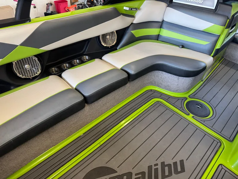 Slide: The Image of 2016 Malibu Wakesetter 23 LSV interior with green and gray seating and speakers. - 10