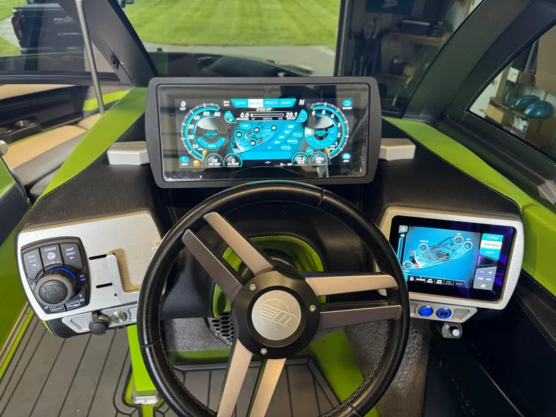 Slide: The Image of 2016 Malibu Wakesetter 23 LSV dashboard with digital displays and steering wheel. - 16