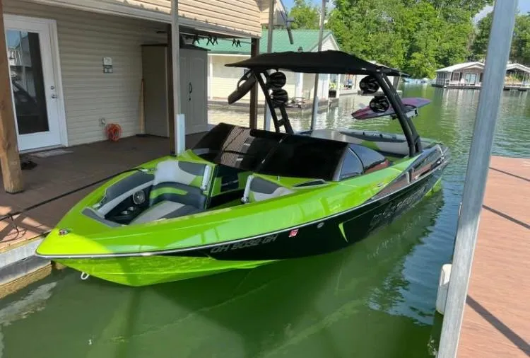 Slide: The Image of 2016 Malibu Wakesetter 23 LSV in vibrant green docked at a marina. - 3