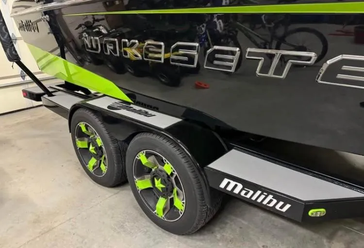 Slide: The Image of 2016 Malibu Wakesetter 23 LSV boat on trailer with green-accented wheels. - 5